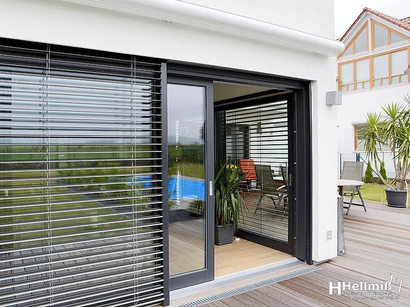 Große Hebeschiebetür mit Raffstores, geöffnet zur Terrasse