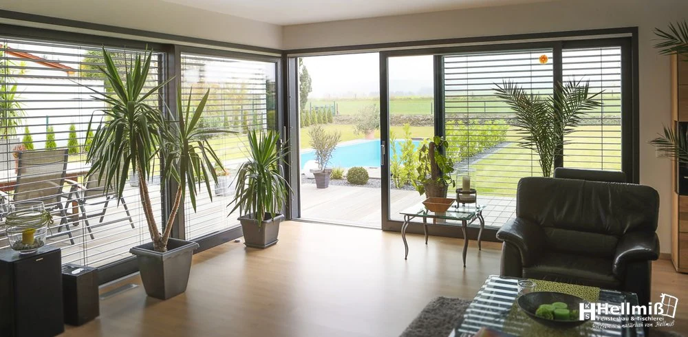 Große Holz-Alu-Schiebetür, die den Wohnraum zur Terrasse öffnet